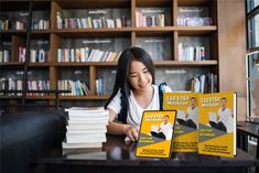 a woman sitting at a table with two books