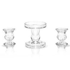 three clear glass candlesticks sitting next to each other