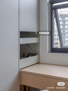 an empty shelf in the corner of a room next to a window with a view of skyscrapers