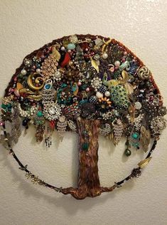 a tree made out of beads and other things hanging on the side of a wall