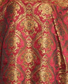 a red and gold blanket on top of a bed