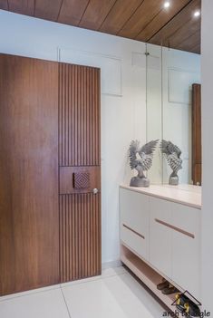 a bathroom with a wooden door and mirror