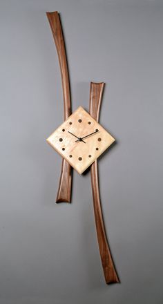 a wooden clock hanging from the side of a wall next to a pair of scissors