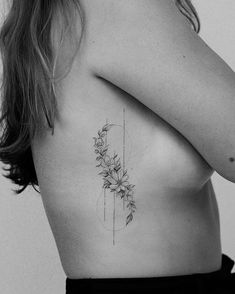 black and white photo of a woman's back with flowers on it, tattoo style