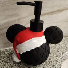 a mickey mouse soap dispenser is decorated with red, white and black foam