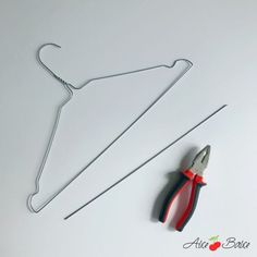 a pair of pliers and wire hangers on a white surface with an apple logo