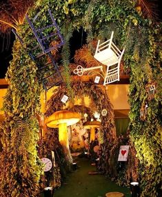 an outdoor area with chairs and plants on the sides, surrounded by greenery at night