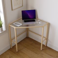 a laptop computer sitting on top of a glass desk next to a window in a room