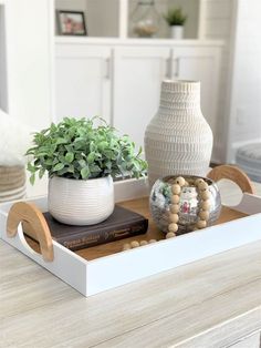 a white vase sitting on top of a wooden tray