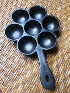 an old cast iron skillet with eight spoons on a wicker tablecloth