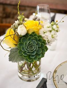 a vase filled with flowers on top of a table next to a plate and silverware