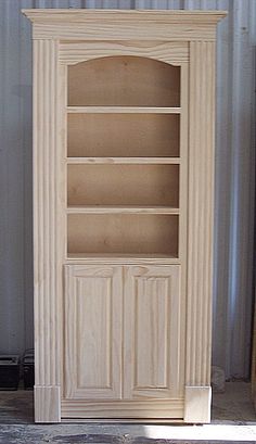 a wooden bookcase sitting in front of a metal container