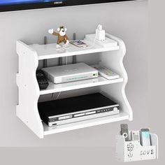 a white entertainment center with remotes and a tv