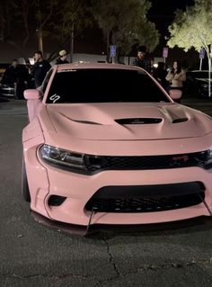 a pink car parked on the street at night