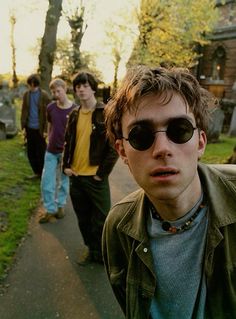 a group of young men walking down a sidewalk next to each other on a sunny day