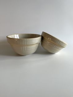 two white bowls sitting next to each other on a table