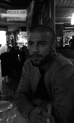 a man sitting at a table with a glass in front of him and the words missed him on it