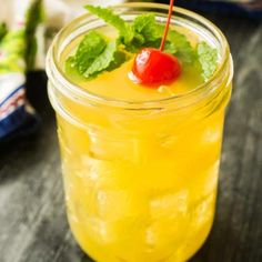 a mason jar filled with lemonade and a cherry