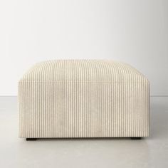 a white ottoman sitting on top of a floor