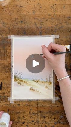 a person is painting on a piece of paper