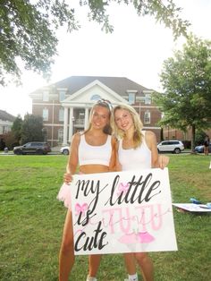 two girls holding up a sign that says, my little sis cut u in pink