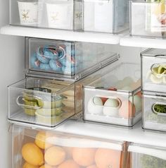 the refrigerator door is open and filled with plastic containers, eggs, and oranges