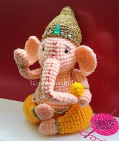 small crocheted gandapa sitting on top of a white table next to a red wall