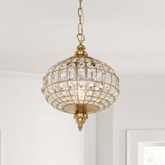 a chandelier hanging from the ceiling in a room with white walls and windows