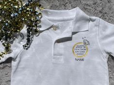 a white polo shirt with gold sequins on the collar, and a name tag