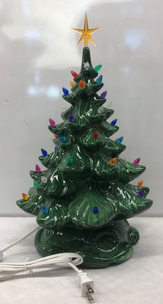 a green ceramic christmas tree with multicolored lights