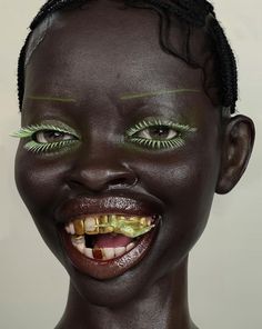 a woman with green makeup and yellow teeth