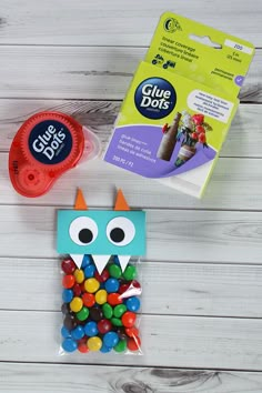 an owl made out of candy sits next to some glue dots