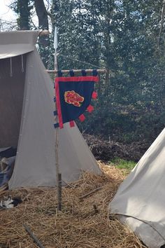 there are two tents with flags in the grass