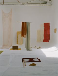 an empty room with several pieces of art hanging on the wall and various objects scattered about