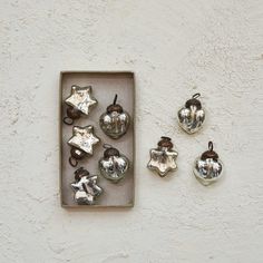 christmas ornaments are displayed in a box on the wall