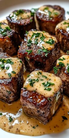 some steaks with sauce and parsley on a white plate, ready to be eaten