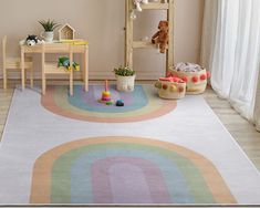 a child's playroom with toys and rugs on the floor in front of a window