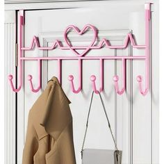 a pink coat rack with hearts on it and a handbag hanging from the hooks