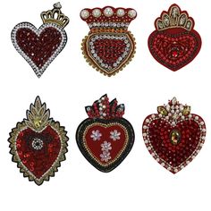 four heart shaped brooches are shown in red, white and gold colors on a white background