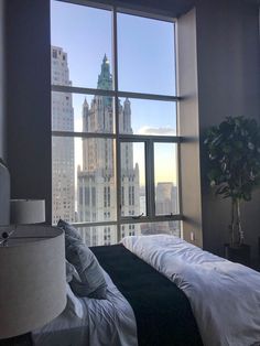 a bedroom with a large window looking out at the city skyline in new york, ny