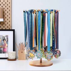 an assortment of medals are hanging on a rack next to a cup and other items