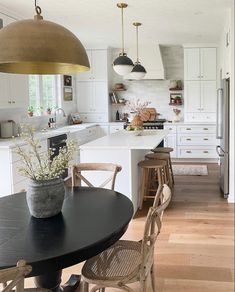 a kitchen filled with lots of white cabinets and counter top next to a dining room table