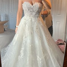 a woman taking a selfie in a wedding dress with her reflection in the mirror