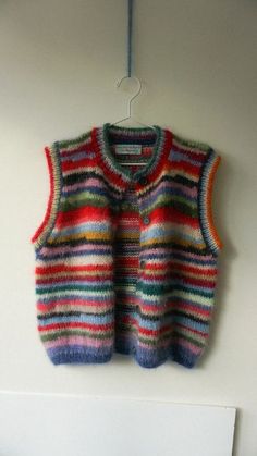 a multicolored sweater vest hanging on a wall