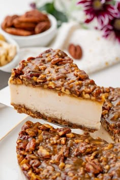 a piece of cheesecake with pecans on the side