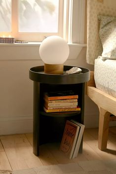 a lamp sitting on top of a book shelf next to a window