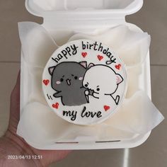 a person holding up a birthday cake with an elephant and cat on it's face