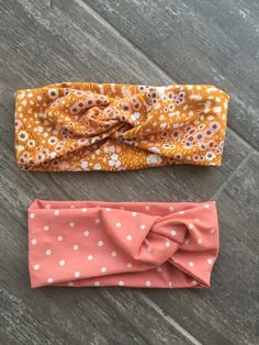 two headbands laying on top of a wooden floor next to eachother