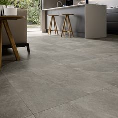 a kitchen with grey tile flooring and counter tops in the middle of the room