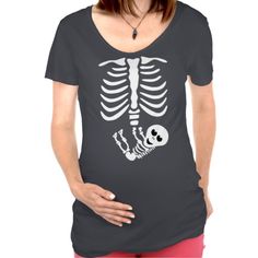 a pregnant woman wearing a skeleton t - shirt with a red flower in her hair